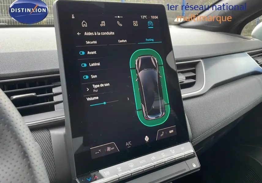 Vue intérieure du tableau de bord du Renault Captur noir étoile métal, avec écran tactile central affichant les aides à la conduite.
