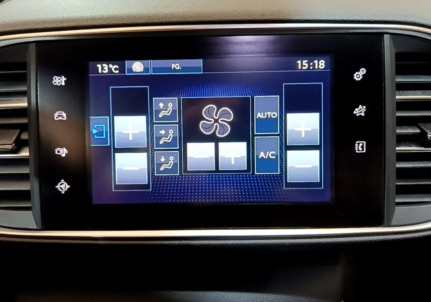 Écran tactile central affichant les commandes de climatisation de la Peugeot 308 gris foncé, vue de face.