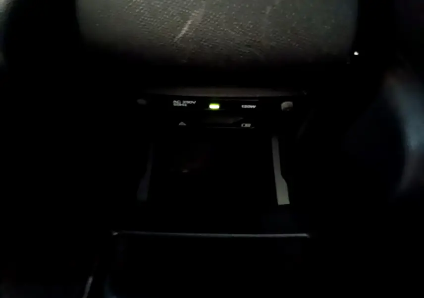 Prise 230V 120W avec témoin lumineux dans l'habitacle sombre d'une Peugeot 308 GT Line gris foncé 2016