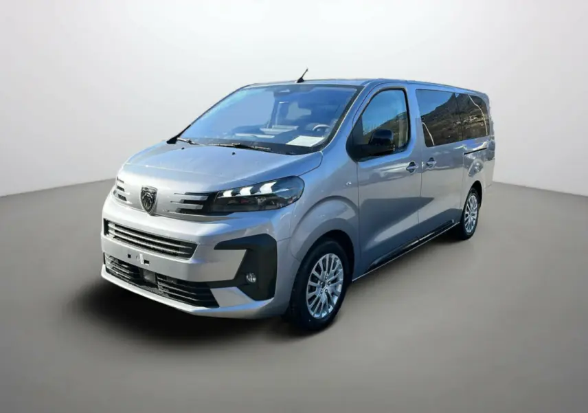 Vue 3/4 avant d'un Peugeot Traveller gris acier avec vitres surteintées et jantes alliage, sur fond neutre.