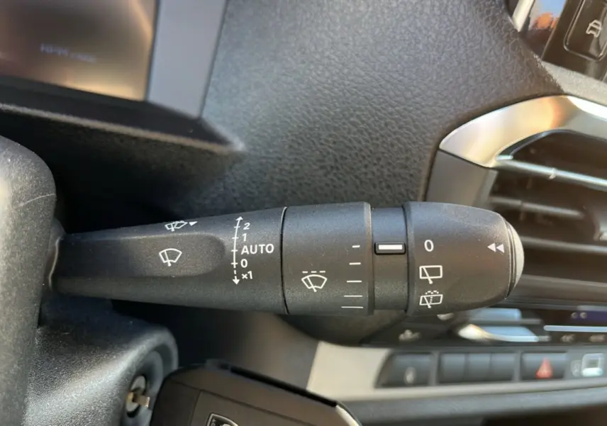 Gros plan sur la commande d’essuie-glace côté gauche du tableau de bord du Peugeot Traveller gris acier 2025.