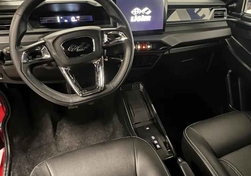 Vue intérieure du tableau de bord et volant du Ligier JS50 BEV 8KWH Elite avec écran tactile et sellerie noire.