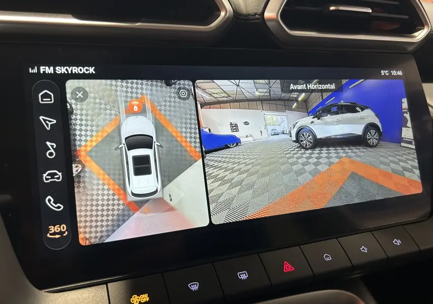 Écran tactile intérieur montrant la caméra 360° avec vue aérienne et latérale droite du MG ZS Hybrid+ blanc dans un garage.
