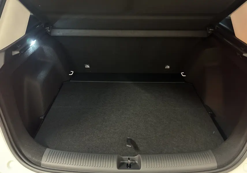 Coffre ouvert du MG Motor ZS Hybrid+ 197 Luxury blanc, montrant l’espace de chargement intérieur et l’éclairage latéral.