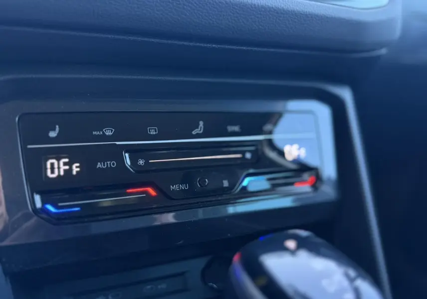 Détail de la console centrale du Volkswagen Tiguan 2024 avec commandes climatisation automatique et levier de vitesse noir brillant.