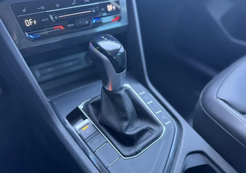 Gros plan sur la console centrale du Volkswagen Tiguan 2024, montrant le levier de vitesse automatique et les commandes de climatisation.