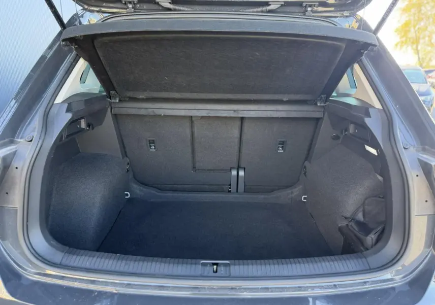 Coffre ouvert vu de l'arrière d'un Volkswagen Tiguan 2024 gris Urano, espace de chargement vide et propre.