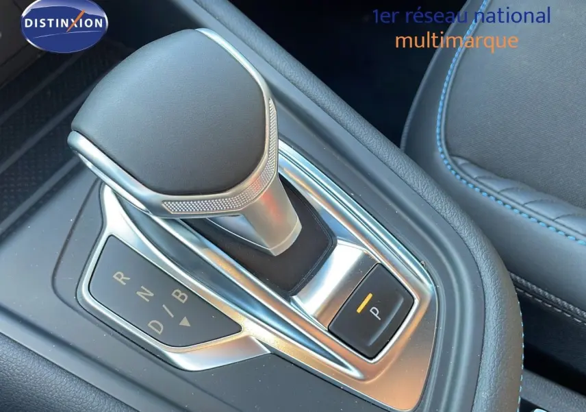 Le levier de vitesses automatique du Renault Captur E-Tech hybride 2025, avec sellerie noire et surpiqûres bleues.