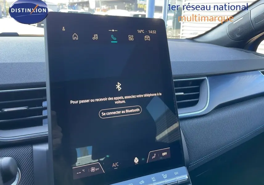 Écran tactile central affichant la connexion Bluetooth dans l'habitacle moderne d'un Renault Captur bleu iron metal toit noir.