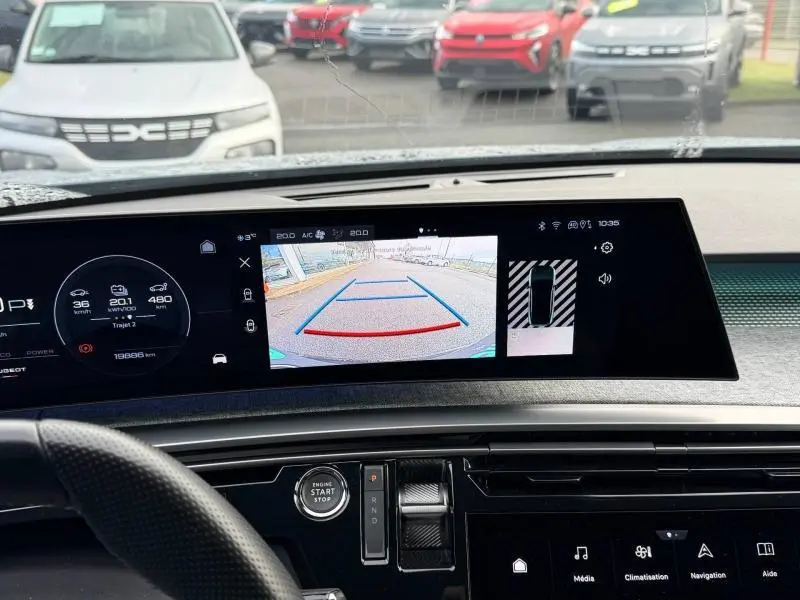 Vue intérieure du tableau de bord du Peugeot 3008 électrique 2024 avec écran de caméra de recul et commandes au volant.