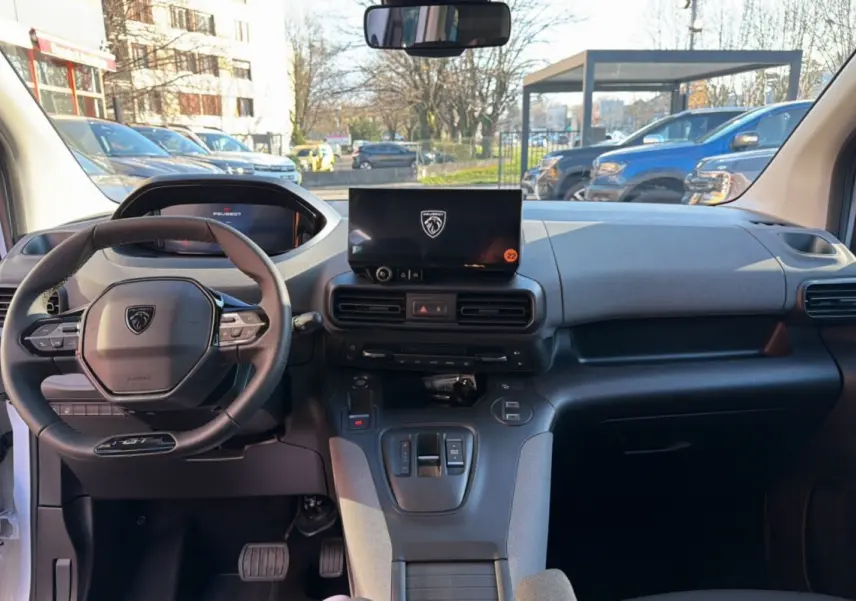 Vue avant de l’intérieur du Peugeot Rifter blanc kaolin 2025, avec volant cuir multifonctions et écran tactile central.