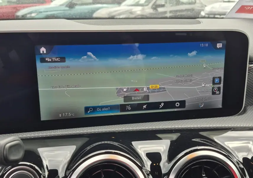 Vue rapprochée de l’écran tactile central du tableau de bord d’une Mercedes Classe A 180d gris foncé avec navigation affichée.