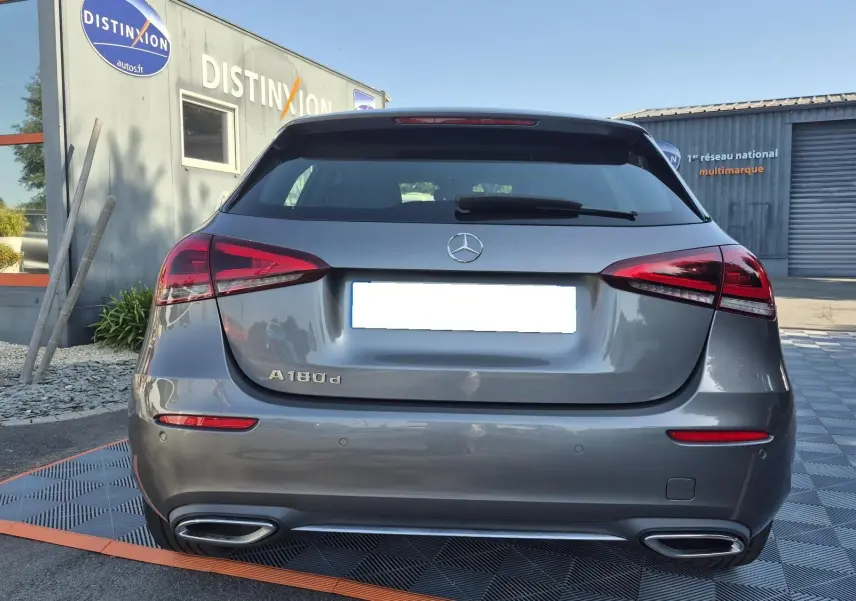 Vue arrière d'une Mercedes Classe A 180d gris foncé, avec feux LED et double sortie d'échappement chromée visible.