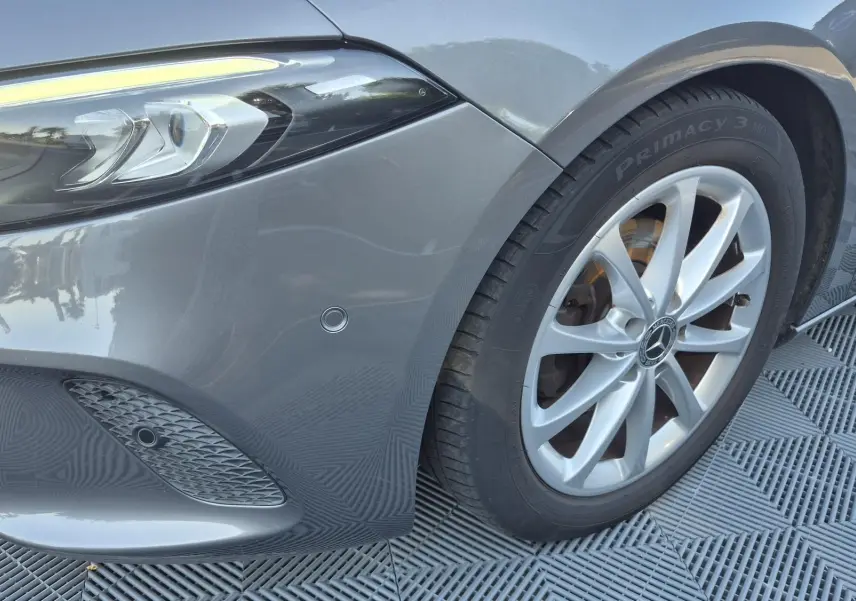 Gros plan sur l'avant droit gris foncé d'une Mercedes Classe A 180d 2020, avec phare LED et jante alliage 17 pouces.