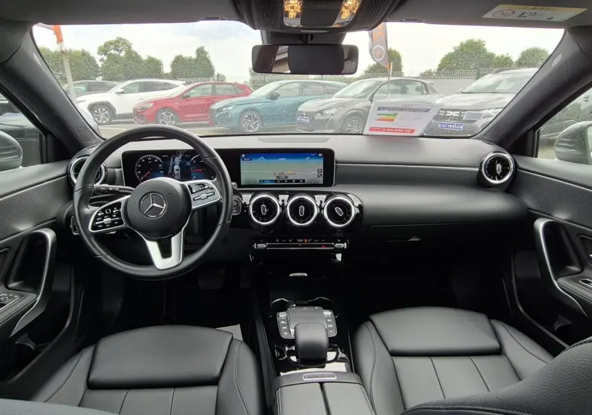 Vue intérieure avant de la Mercedes Classe A 180d 2020, avec tableau de bord moderne et sièges cuir noir.
