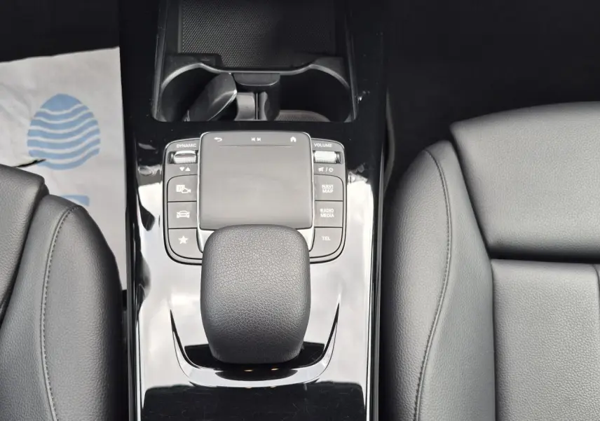 Gros plan sur la console centrale noire brillante et le levier de vitesse cuir noir de la Mercedes Classe A 180d 2020.