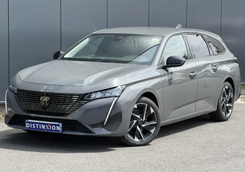 Peugeot 308 SW gris Selenium vue 3/4 avant droit, jantes alliage 17'' et calandre noire distinctive.