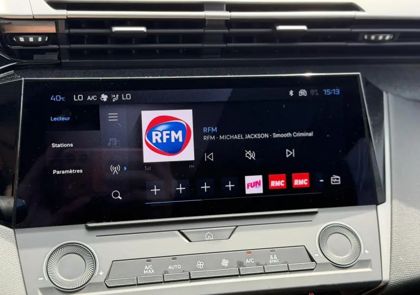 Écran tactile central 10'' du Peugeot 308 SW 2025, affichant la radio RFM, avec commandes climatisation en dessous.