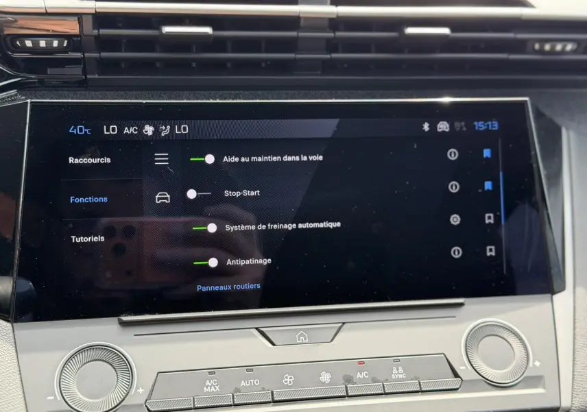 Gros plan sur l’écran tactile central de la Peugeot 308 SW 2025 affichant les aides à la conduite, intérieur gris Selenium.