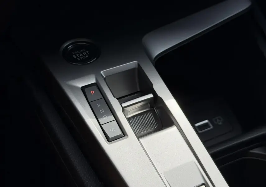 Gros plan sur la console centrale argentée avec sélecteur de boîte automatique et bouton start/stop dans une Peugeot 308 SW 2025.