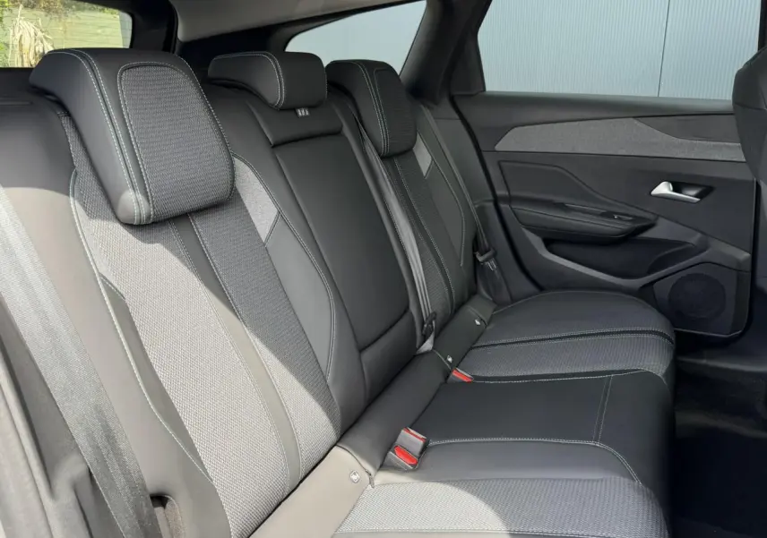 Vue latérale droite des sièges arrière en sellerie tri matières noire et grise de la Peugeot 308 SW 2025.