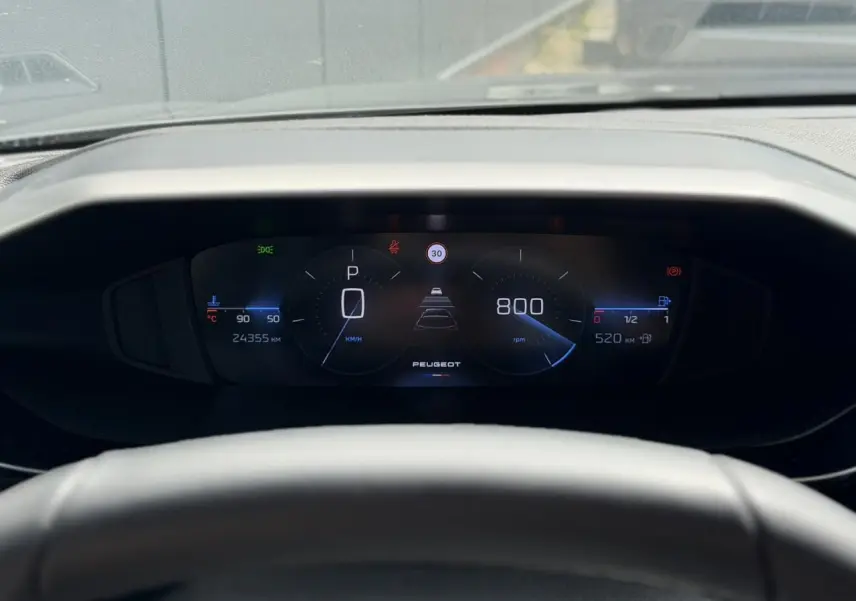 Vue rapprochée du tableau de bord numérique du Peugeot 308 SW 2025, affichage digital clair avec compteur et indicateurs.
