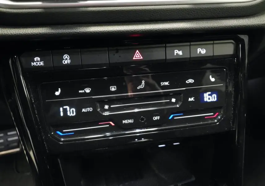 Vue rapprochée du panneau de commande de climatisation automatique bi-zone noir brillant du Volkswagen T-Roc gris 2025 R-Line.