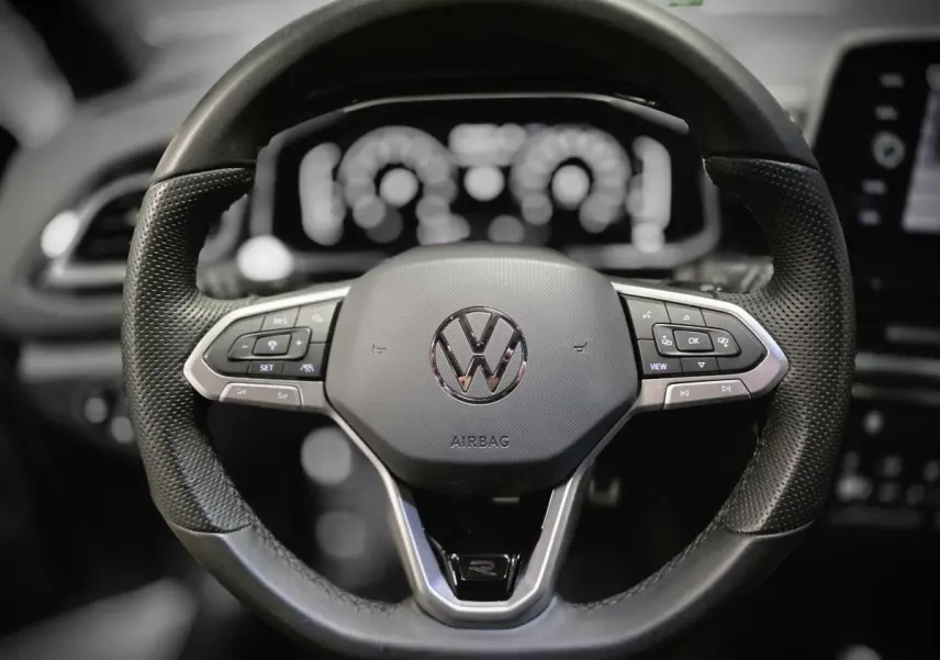 Volant sport en cuir noir avec logo VW et commandes multifonctions du Volkswagen T-Roc 2025, vue frontale rapprochée.