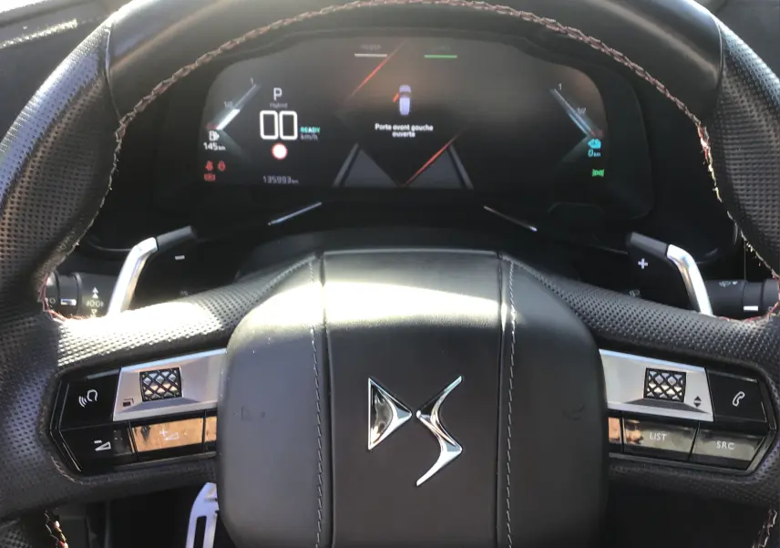 Vue intérieure centrée sur le volant en cuir noir perforé et le tableau de bord numérique du DS7 Crossback 2023.