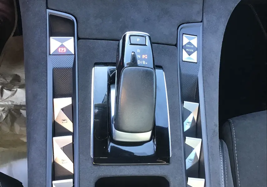 Vue rapprochée de la console centrale noire du DS7 Crossback 2023 avec levier de vitesses et boutons argentés.