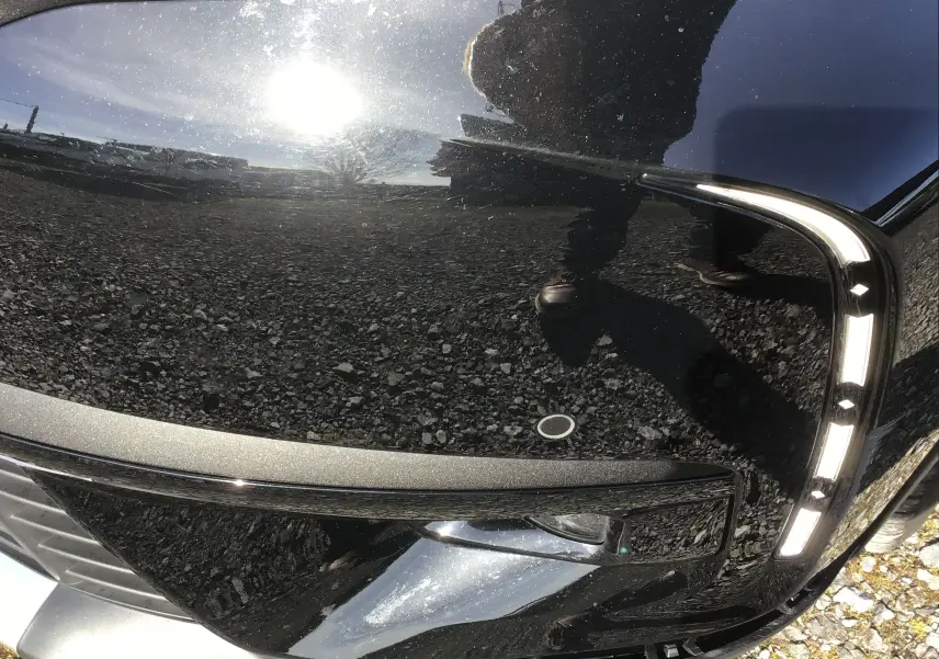 Gros plan sur le phare avant droit noir brillant du DS7 Crossback 2023 avec éclairage LED distinctif en forme de boomerang.