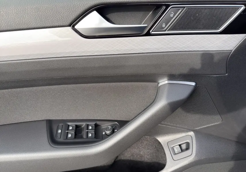 Détail de la porte côté conducteur de la Volkswagen Passat SW 2.0 TDI 2022 avec commandes de vitres et verrouillage, finition gris noir.