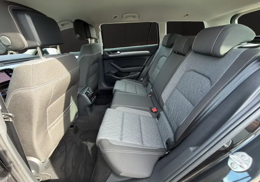 Vue intérieure arrière côté droit de la Volkswagen Passat SW 2.0 TDI avec sièges tissu gris et détails noirs.
