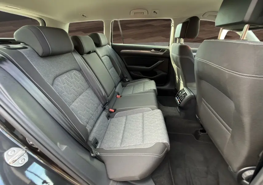 Vue intérieure côté gauche des sièges arrière gris tissu avec surpiqûres blanches de la Volkswagen Passat SW 2022.