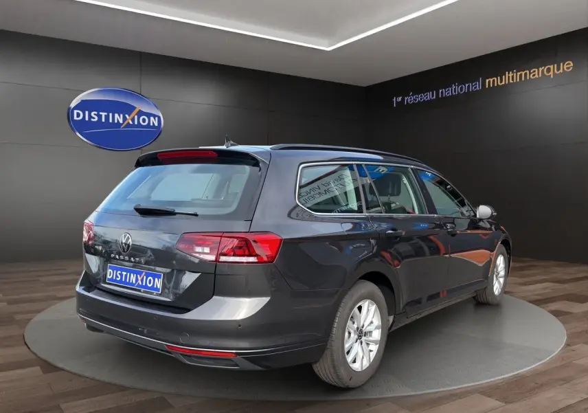 Volkswagen Passat SW gris manganese vue 3/4 arrière droit, avec jantes alliage et caméra de recul visible.