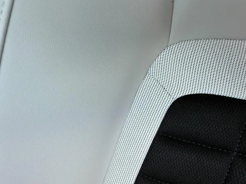 Détail du tissu de siège bicolore noir et blanc du Citroën C3 Aircross 2026, version hybride.