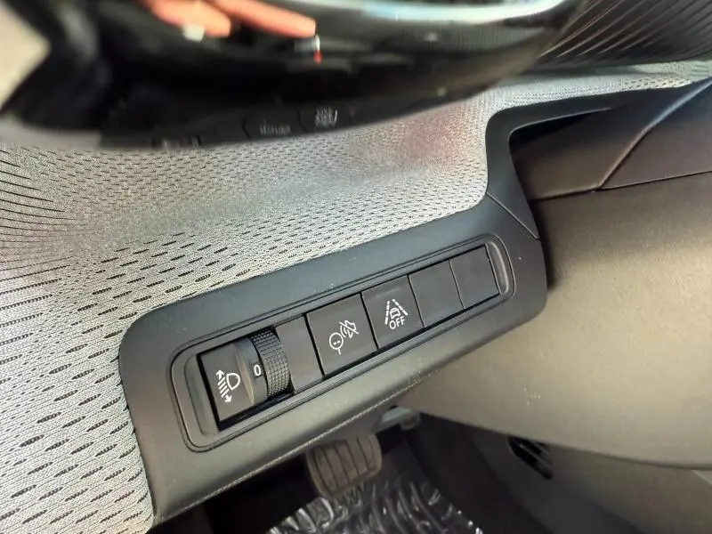 Vue rapprochée des commandes d'assistance au conducteur côté gauche, intérieur gris et noir du Citroën C3 Aircross 2026.