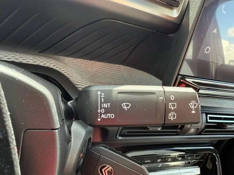Gros plan sur la commande d’essuie-glace côté gauche du tableau de bord du Citroën C3 Aircross vert Montana.