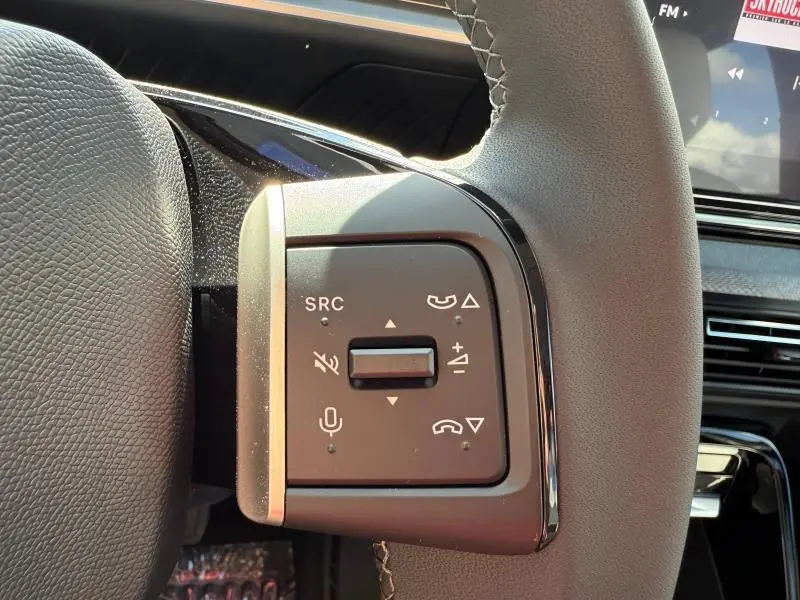 Gros plan sur les commandes multifonctions au volant côté gauche du Citroën C3 Aircross 2026, finition Vert Montana.