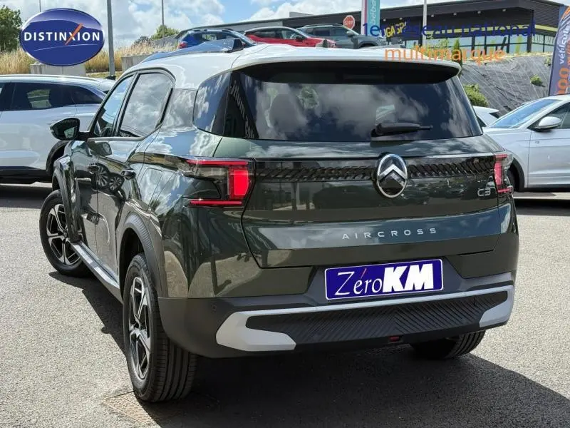Vue 3/4 arrière droite d'un Citroën C3 Aircross Vert Montana avec toit blanc et feux arrière LED distinctifs.
