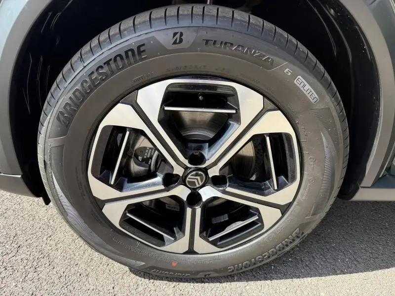 Gros plan sur la jante alu noire et argentée avec logo Citroën, montée d’un pneu Bridgestone Turanza.