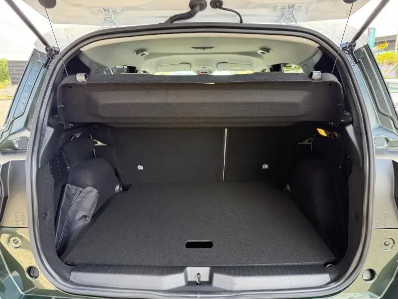Coffre ouvert vu de l'arrière du Citroën C3 Aircross Vert Montana avec cache-bagages et intérieur noir.
