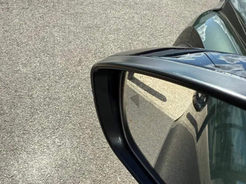 Rétroviseur droit d'une Citroën C3 Aircross Vert Montana, vue rapprochée avec reflet du capot et triangle d'alerte.