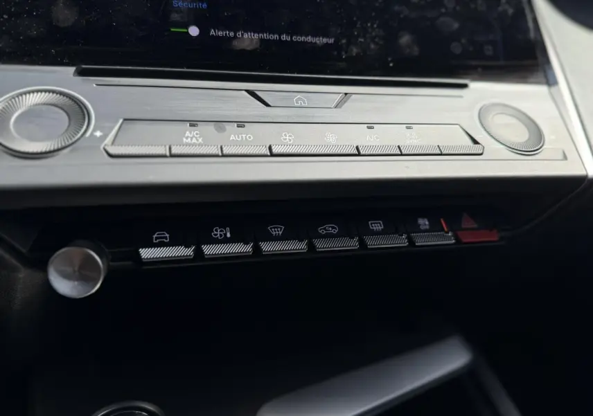 Vue rapprochée du tableau de bord de la Peugeot 308 SW 2025, mettant en valeur les commandes de climatisation et les boutons fonctionnels.
