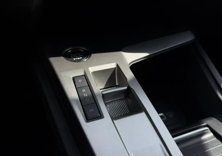 Gros plan sur la console centrale grise du Peugeot 308 SW 2025 avec sélecteur de boîte auto et bouton start/stop.