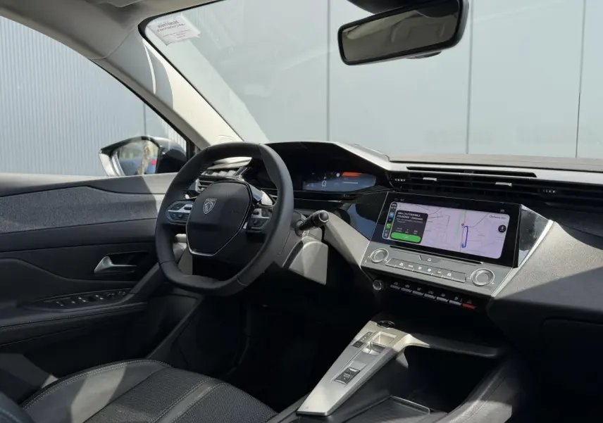 Intérieur avant droit du Peugeot 308 SW 2025, tableau de bord moderne avec écran tactile et volant cuir noir.