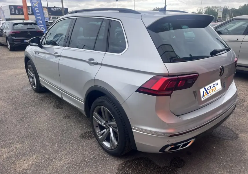 Volkswagen Tiguan 1.4 eHybrid gris dauphin métallisé vu 3/4 arrière droit avec jantes alu et barres de toit.