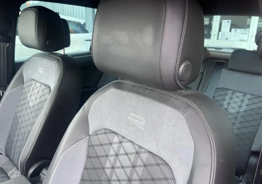 Gros plan sur les sièges avant en cuir et tissu gris avec logo R brodé, intérieur du Volkswagen Tiguan 2023.