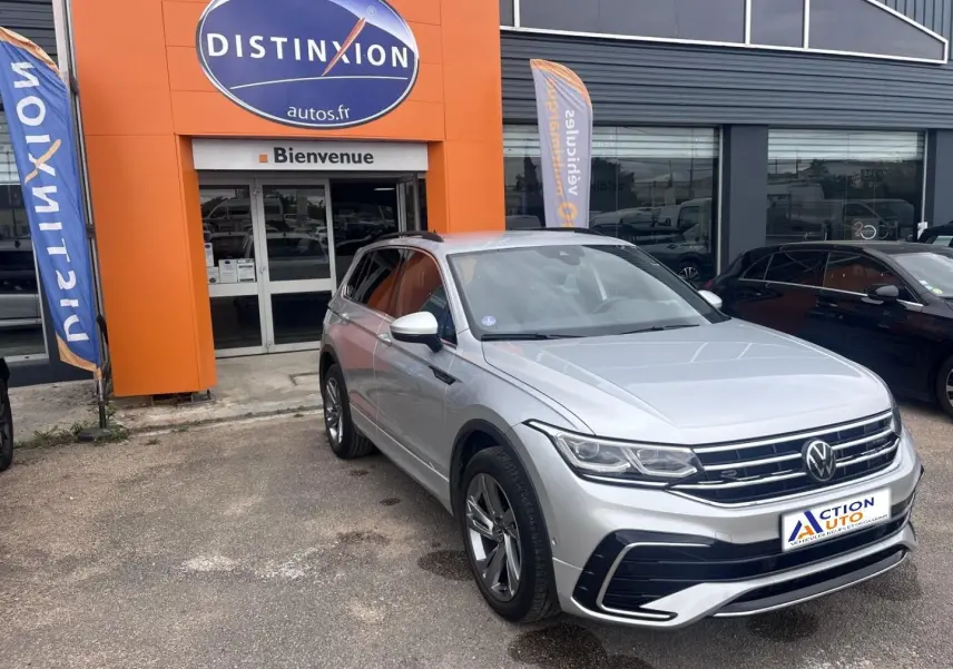 Volkswagen Tiguan 1.4 eHybrid gris dauphin métallisé, vue 3/4 avant droit devant un garage Distinxion.