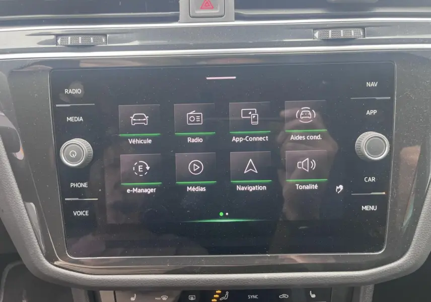 Écran tactile central du Volkswagen Tiguan 2023 affichant le menu principal avec options multimédia et navigation.
